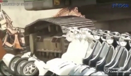  Cảnh sát dùng máy xúc cán nát hàng trăm xe Vespa nhập lậu trị giá hàng triệu đôla